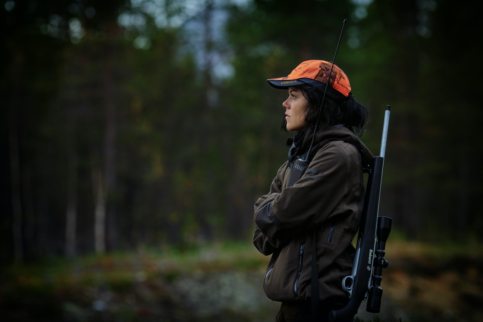 woman carrying hunting rifle in woods